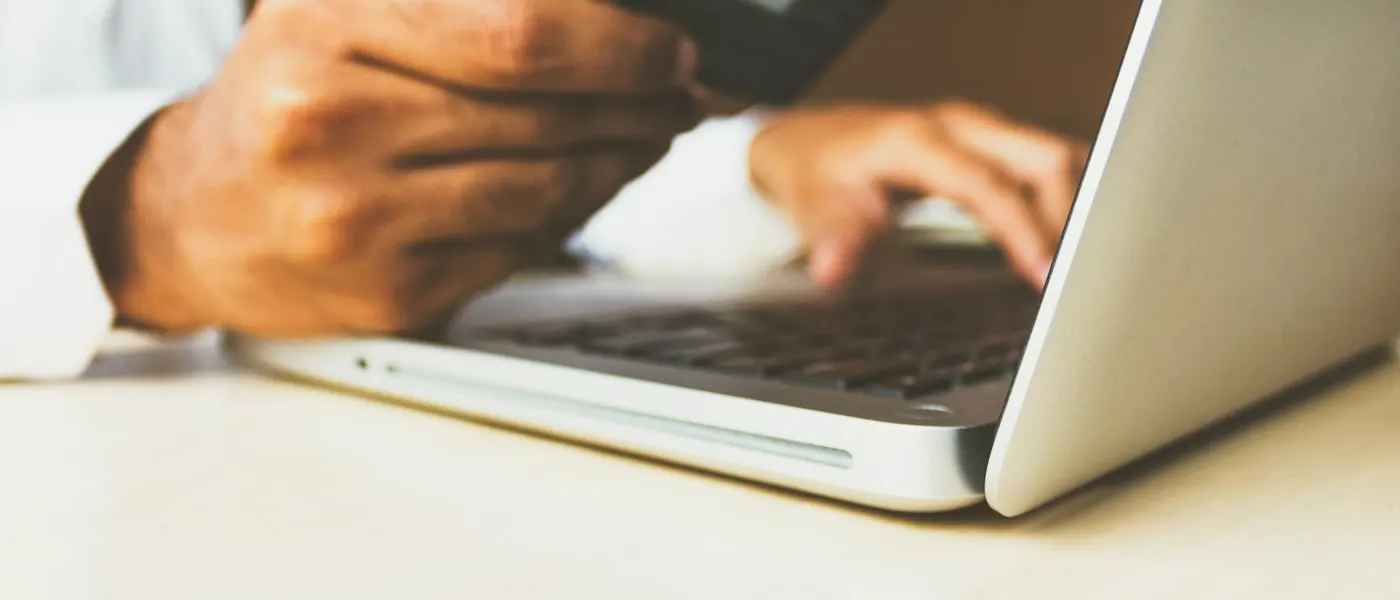 Business owner paying online with a bank card at a laptop