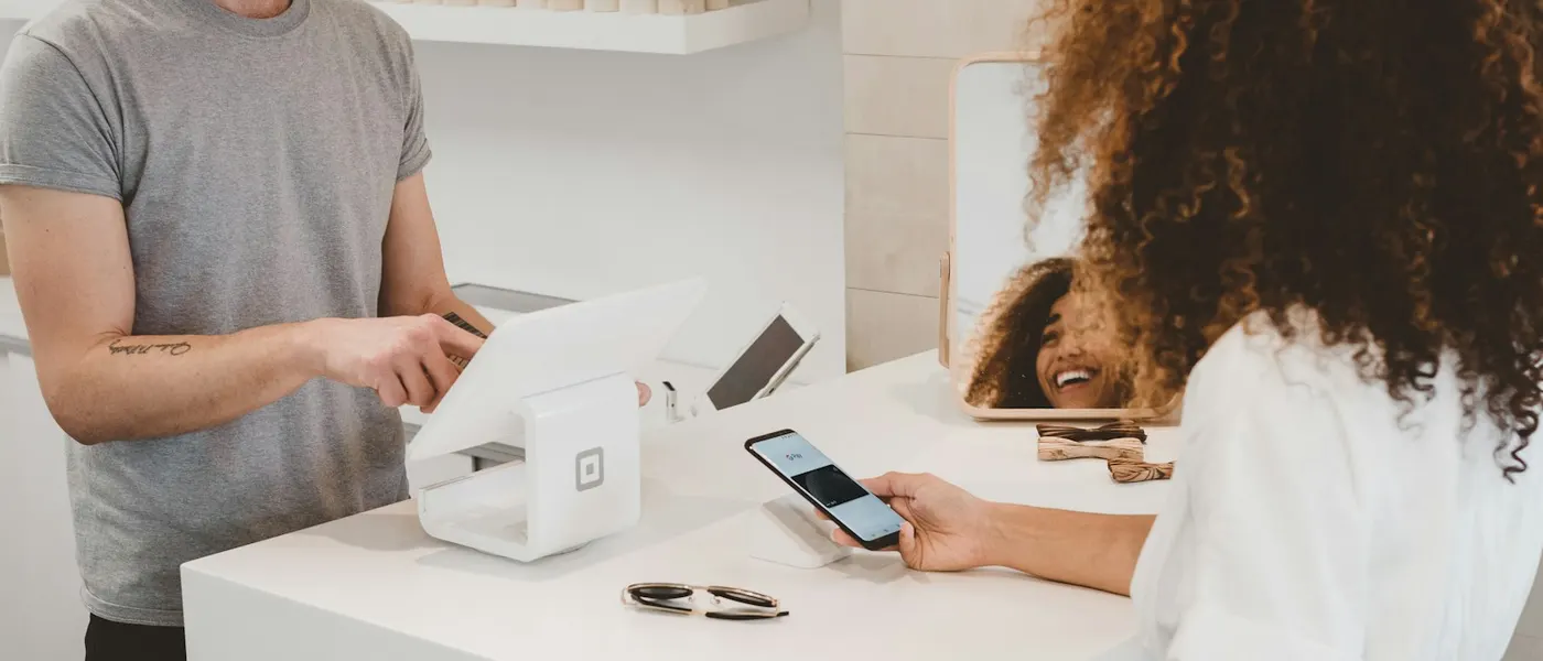 Shop owner taking a contactless card payment at the till